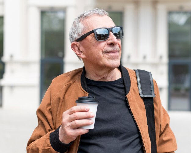 Uomo del colpo medio che tiene la tazza di caffè