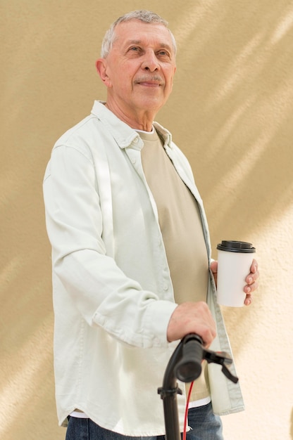 Uomo del colpo medio che tiene la tazza di caffè