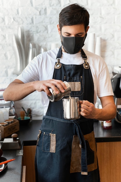 Uomo del colpo medio che versa il latte