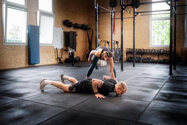 Uomo del colpo pieno che fa i burpees all'interno