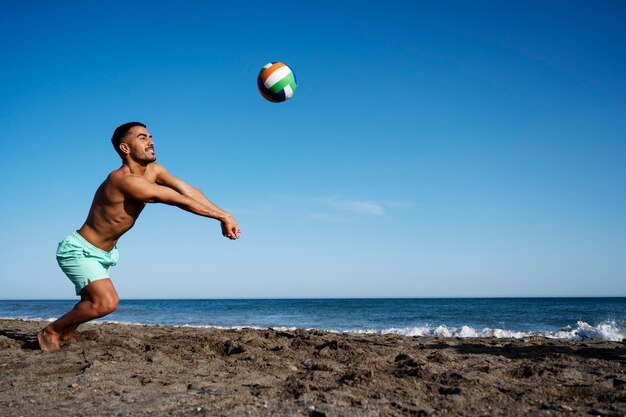 Uomo del colpo pieno che gioca a pallavolo