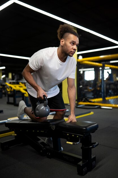 Uomo del colpo pieno che si esercita con il kettlebell