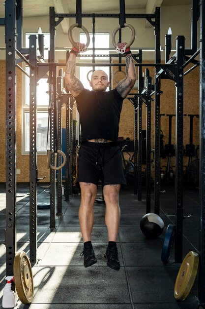 Uomo del colpo pieno che si esercita in palestra