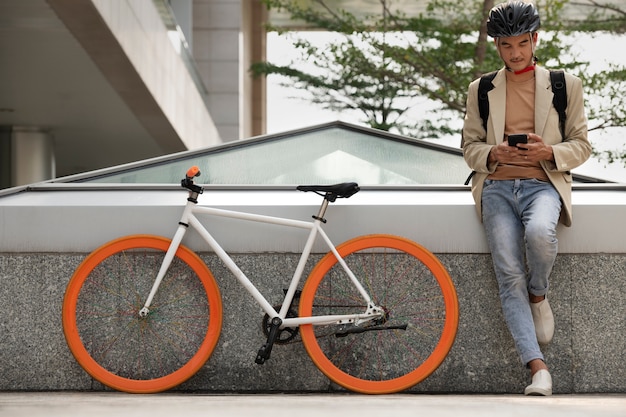 Uomo del colpo pieno con la bicicletta all'aperto