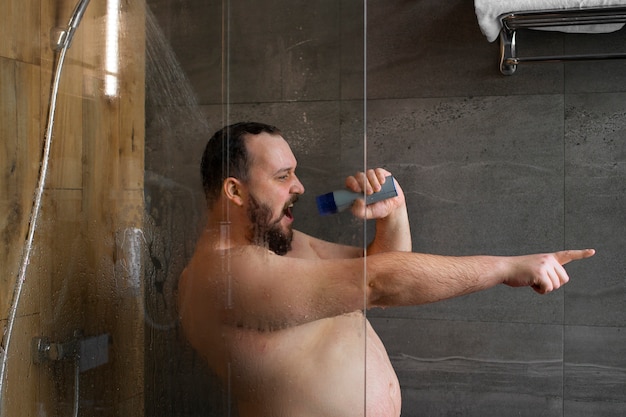Uomo del piano medio che canta sotto la doccia