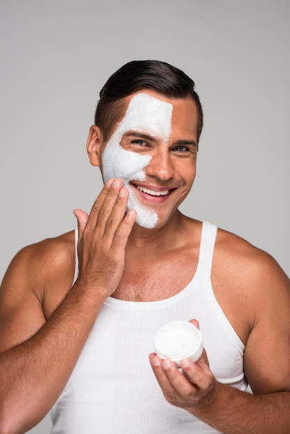 Uomo del primo piano che applica la maschera per il viso