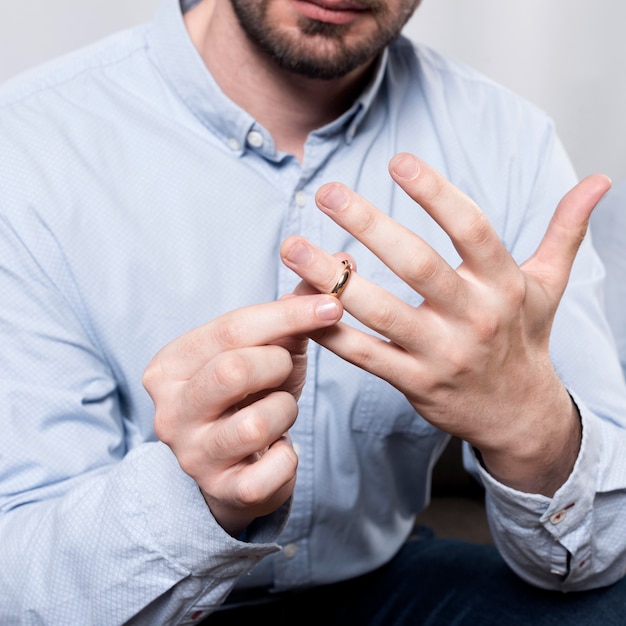 Uomo del primo piano che elimina la fede nuziale dal dito