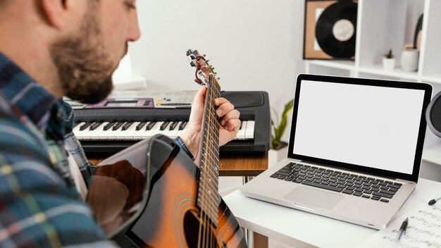 Uomo del primo piano che gioca la chitarra