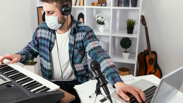 Uomo del primo piano che gioca piano digitale