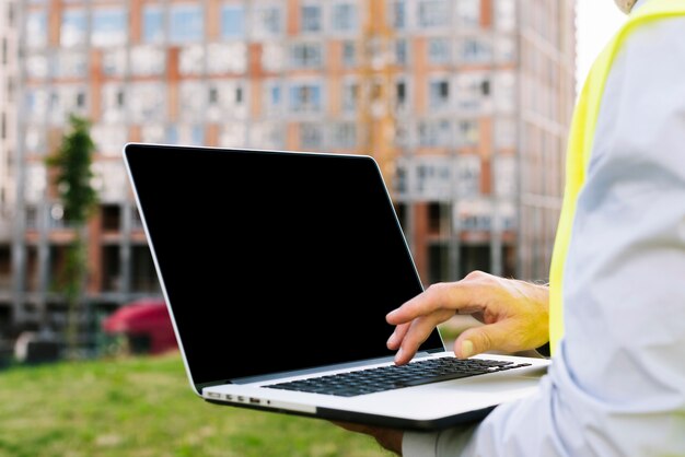 Uomo del primo piano che ostacola il modello del computer portatile