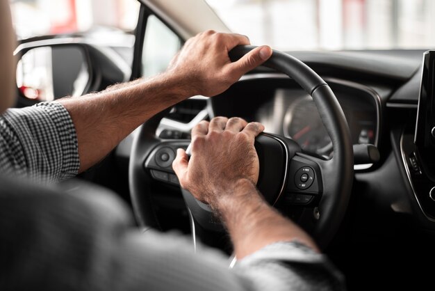 Uomo del primo piano che prende automobile per una prova su strada