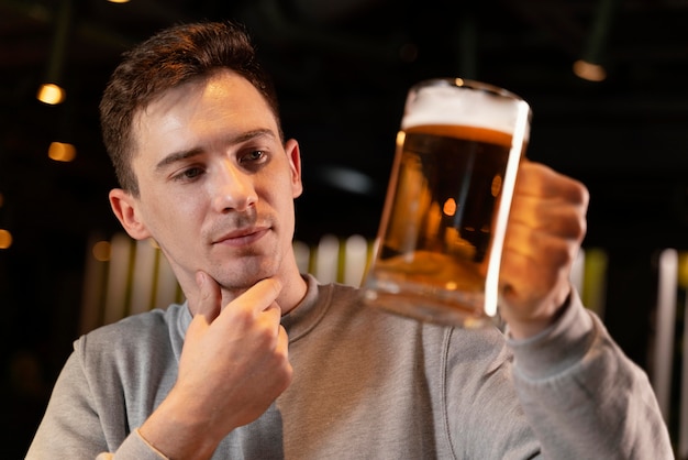 Uomo del primo piano che tiene boccale di birra