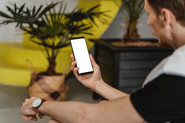 Uomo del primo piano che tiene smartphone