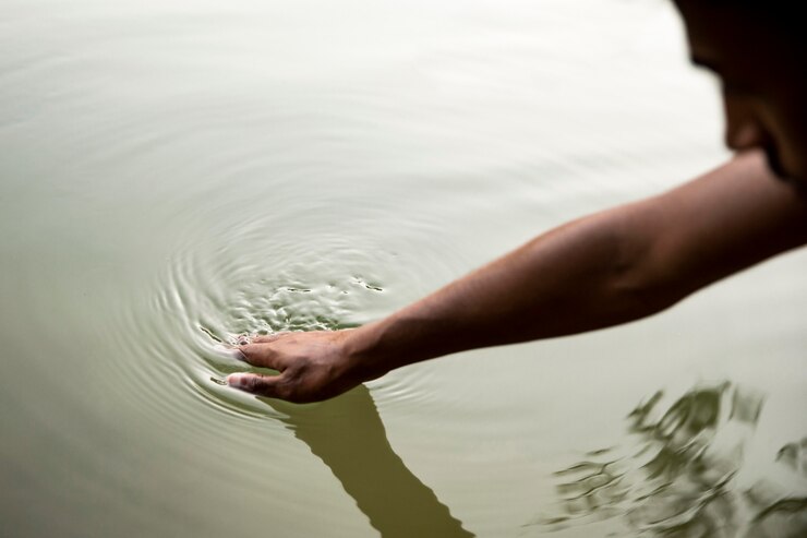 Foto gratuito uomo del primo piano che tocca l'acqua