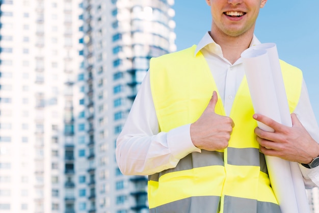 Uomo del primo piano con la maglia di sicurezza che mostra approvazione