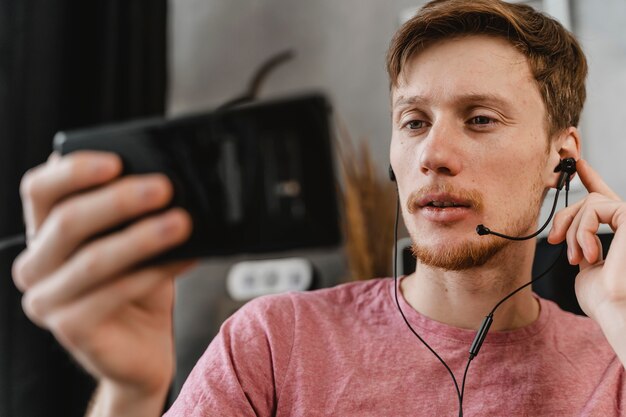 Uomo del primo piano in streaming con il telefono