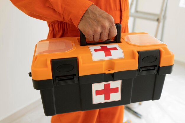 Uomo del ritratto con equipaggiamento di protezione di sicurezza e kit di pronto soccorso