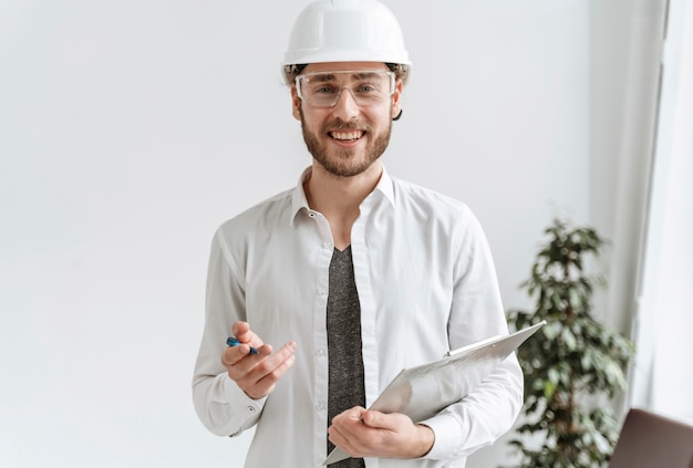 Uomo del ritratto con il casco in ufficio