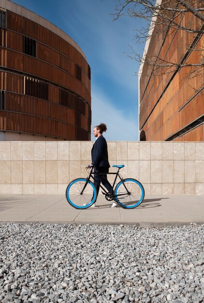 Uomo del tiro lungo con la bicicletta che va al lavoro