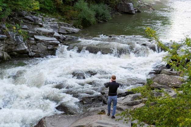 Uomo del tiro lungo in piedi vicino al fiume