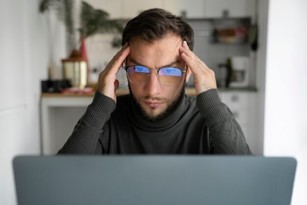 Uomo del tiro medio che lavora al computer portatile