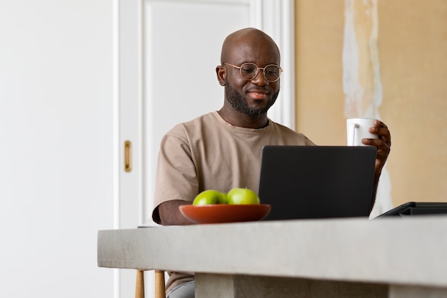 Uomo del tiro medio che lavora al computer portatile