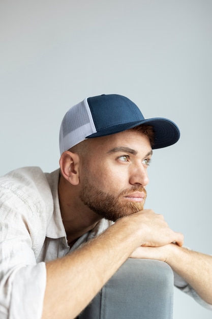 Uomo del tiro medio che posa con il cappello del camionista