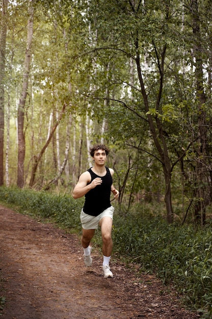 Uomo dell'angolo alto che corre nella natura