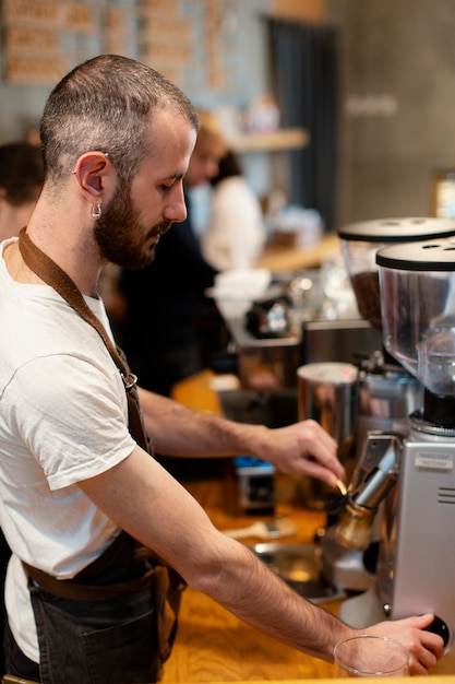 Uomo dell'angolo alto che lavora nella caffetteria