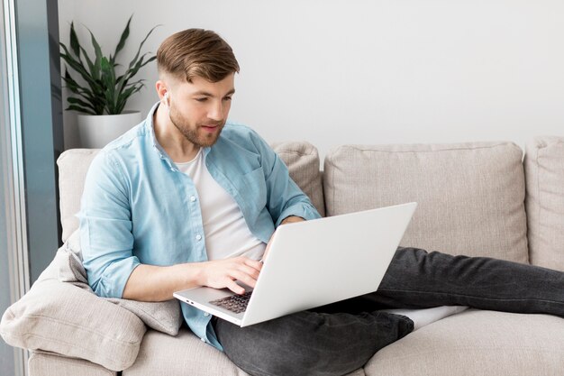 Uomo dell'angolo alto sullo strato con il computer portatile