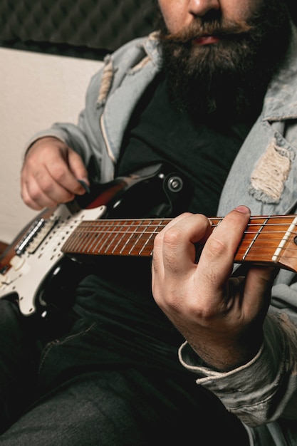 Uomo della barba che gioca chitarra elettrica