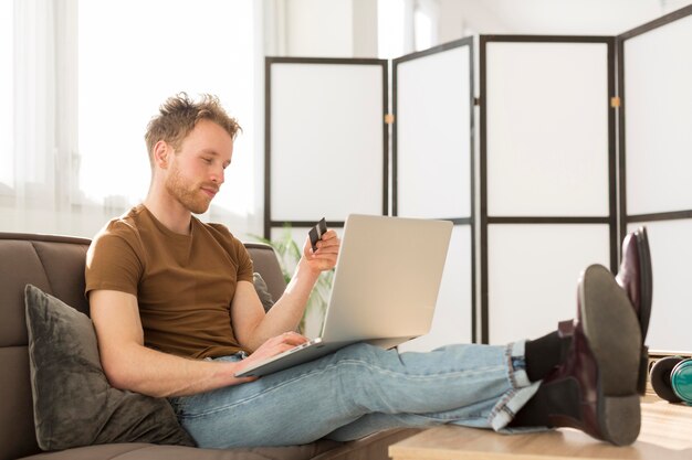 Uomo della foto a figura intera che compera online