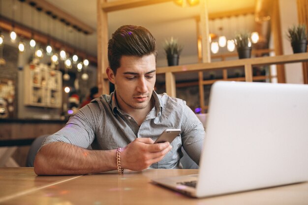 Uomo di affari che comunica sul telefono in un caffè