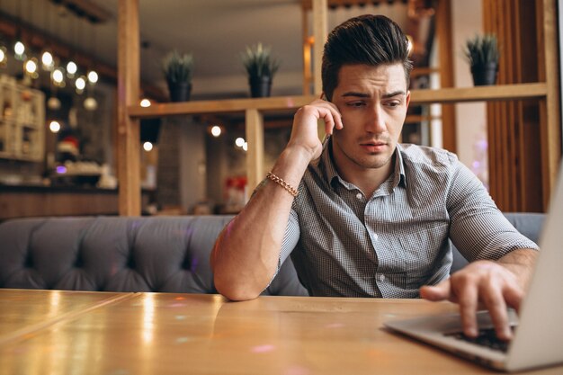 Uomo di affari che comunica sul telefono in un caffè