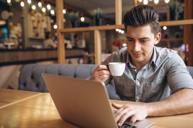 Uomo di affari che lavora al computer portatile in un caffè