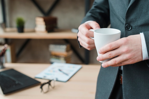 Uomo di affari che lavora in un desktop dell&#39;ufficio