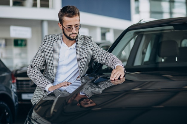 Uomo di affari che sceglie un'auto in uno showroom di auto