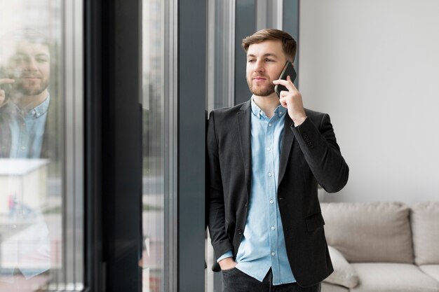 Uomo di affari del ritratto che parla sopra il telefono