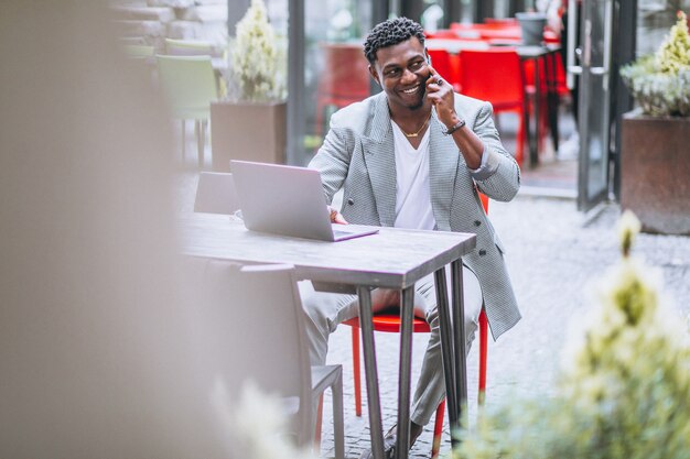 Uomo di affari dell&#39;afroamericano che utilizza computer portatile in un caffè