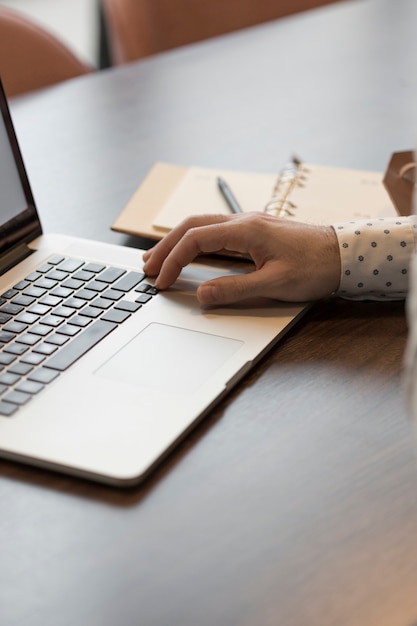 Uomo di affari dell'angolo alto con il computer portatile