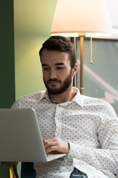 Uomo di affari di angolo basso che lavora al computer portatile