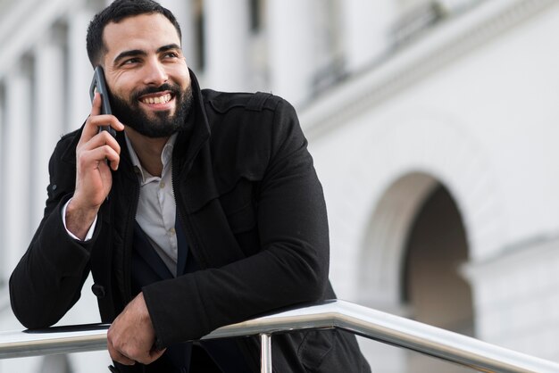 Uomo di affari di angolo basso che parla sopra il telefono