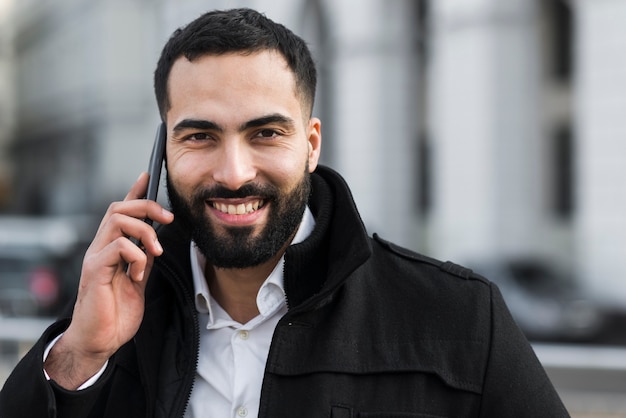 Uomo di affari di vista frontale che parla al telefono