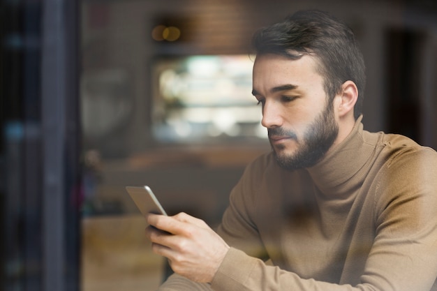 Uomo di affari di vista laterale che controlla cellulare