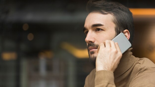 Uomo di affari di vista laterale che parla sul cellulare