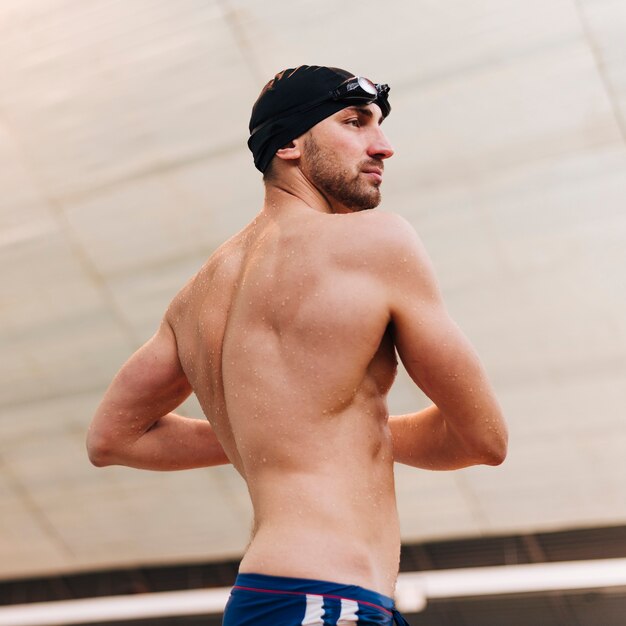 Uomo di angolo basso che allunga prima del nuoto