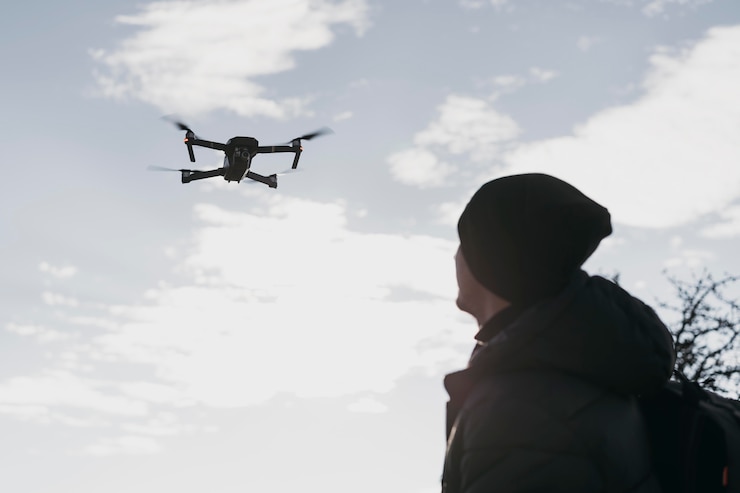 Foto gratuito uomo di angolo basso che guarda drone