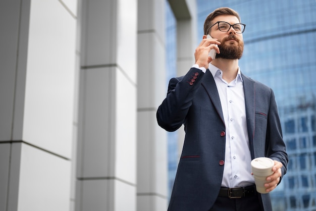 Uomo di angolo basso che parla al telefono