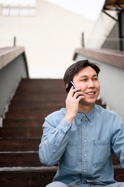 Uomo di angolo basso che parla sopra il telefono