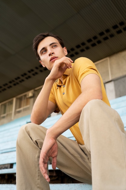 Uomo di angolo basso che posa all'aperto